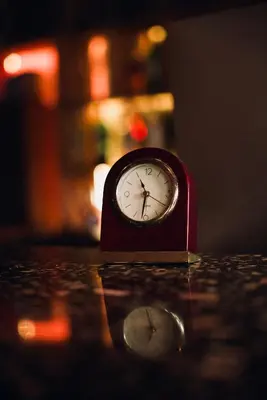 a small red clock sitting on top of a table at Ḥokma Boutique Hotel & Tropical Lounge in Phi Phi Don