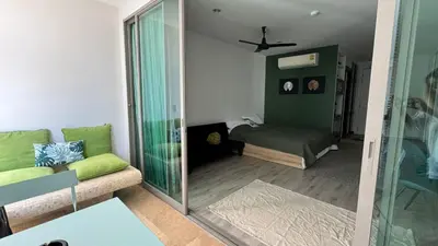 a living room with a green couch and a bedroom at The Regent Bangtao Spacious and comfortable studio at Bang Tao area in Bang Tao Beach