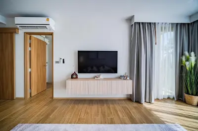 a living room with a flat screen tv on a wall at Beachside Residences by NLA in Bang Tao Beach