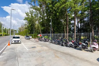 a row of motorcycles parked in a parking lot at Beachside Residences by NLA in Bang Tao Beach