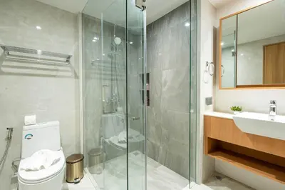 a bathroom with a shower and a toilet and a sink at Beachside Residences by NLA in Bang Tao Beach