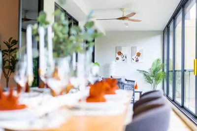 a dining room with tables and chairs and windows at Beachside Residences by NLA in Bang Tao Beach