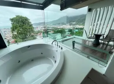 a large white bath tub in a room with a large window at Thebirdhouse Patong Phuket201 in Patong Beach