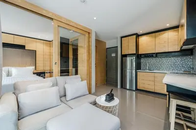 a living room with a white couch and a kitchen at C225 City Gate Kamala Great facilities 600m to beach in Kamala Beach