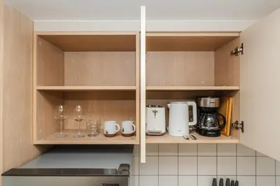a kitchen with wooden cabinets with glasses and appliances at C169 Part of the famous Fantasea Kamala in Kamala Beach