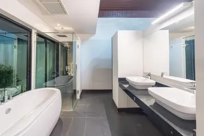 a bathroom with two sinks and two mirrors at Pasak Villa in Laguna Phuket