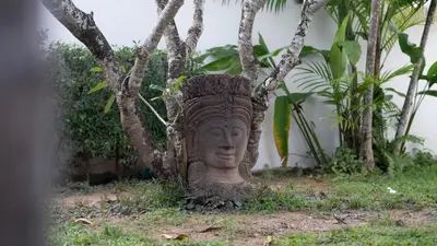 a statue of a head in front of a tree at Pasak Villa in Laguna Phuket
