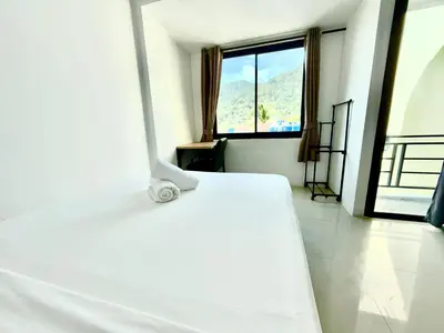 a white bed in a room with a window at Patong Easy Life 7 in Patong Beach