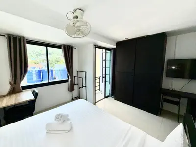 a bedroom with a white bed and a television at Patong Easy Life 7 in Patong Beach