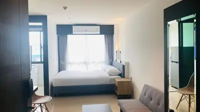 a hotel room with a bed and a window at Utopia Central Kathu Condo in Phuket Town