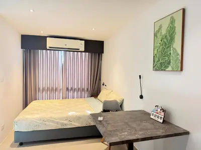 a small bedroom with a bed and a table at Utopia Central Kathu Condo in Phuket Town