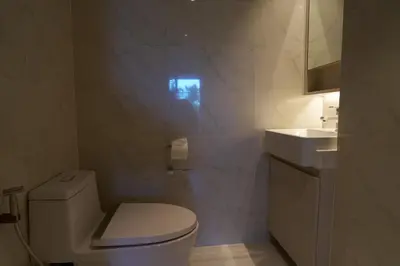 a white bathroom with a toilet and a sink at Cassia Residences 1BDR Lake view in Laguna Phuket