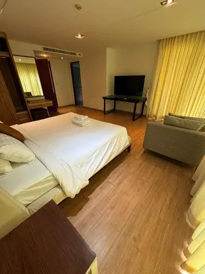 a hotel room with a large bed and a television at Privilège résidence patong in Patong Beach