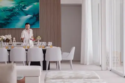 a man standing at a table in a dining room at Villa AMANN in Phuket Town