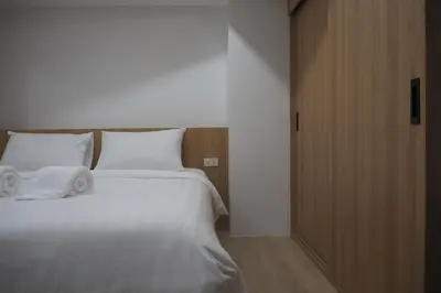 a bedroom with a large white bed with towels on it at Cozy room Maikhao Phuket in Ban Ao Tu Khun