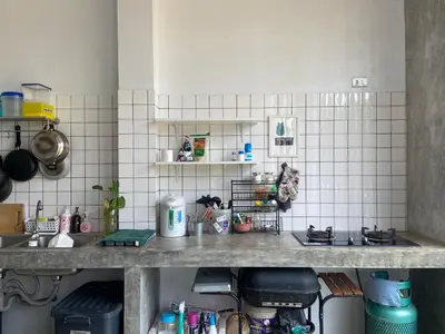 a kitchen with a counter top with a sink and shelves at Cozy room Maikhao Phuket in Ban Ao Tu Khun