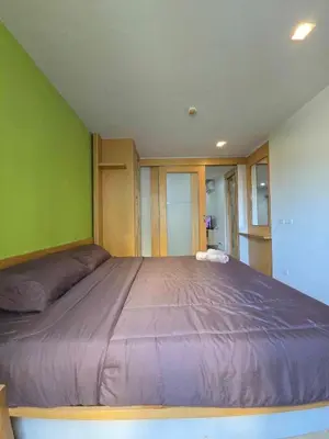 a large bed in a room with green walls at The feeltrue phuket CK in Phuket Town