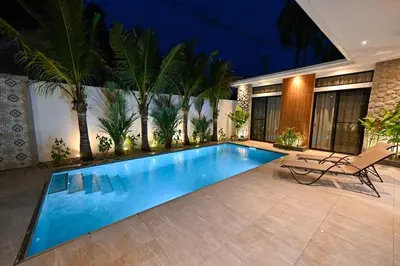 a swimming pool with a chair and palm trees at Diamond 2 Villa by G Estate Phuket in Ban Saiyuan (1)