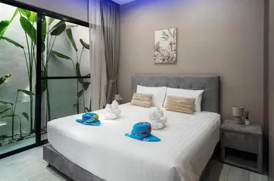 a bedroom with two stuffed animals with hats on a bed at Diamond 2 Villa by G Estate Phuket in Ban Saiyuan (1)
