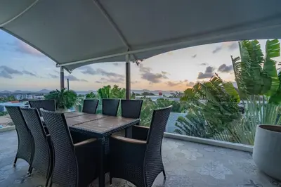 a table with chairs and an umbrella on a balcony at Luxury Seaview Villa 6BR - Villa Shine in Ban Saiyuan (1)