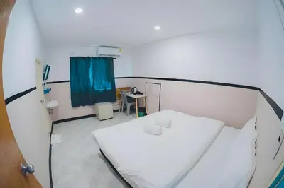 a hospital room with a white bed and a blue curtain at XX Mitr Inn Phuket Old Town -มิตร อินน์ ภูเก็ตโอลทาวน์ in Phuket Town