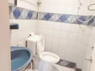 a bathroom with a white toilet and a blue sink at XX Mitr Inn Phuket Old Town -มิตร อินน์ ภูเก็ตโอลทาวน์ in Phuket Town