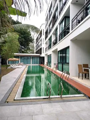 a swimming pool in front of a building at Private apartment at Kris Condo by Lofty in Surin Beach