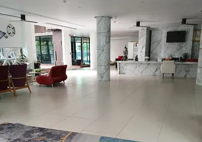 a large living room with a red chair and a table at Private apartment at Kris Condo by Lofty in Surin Beach