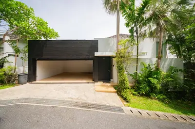 a garage in a house with a black door at Surin Heights Villa in Surin Beach