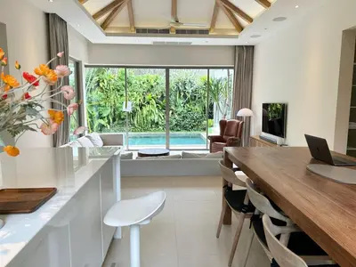 a kitchen and dining room with a table and aaptop at V164 Famous 5 Trichada Resort 4-Bedroom in Thalang