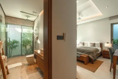 a bedroom with a bed and a bathroom at V165 Famous Anchan Flora 4 BR in Thalang