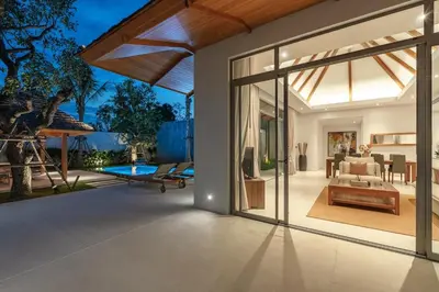 an open patio with a living room and a pool at V165 Famous Anchan Flora 4 BR in Thalang