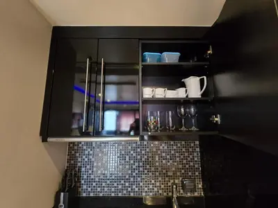 a kitchen with a black cabinet with a sink at Absolute Bangla Jacuzzi Suites Condo in Patong Beach