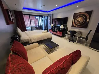 a bedroom with a couch and a bed and a desk at Absolute Bangla Jacuzzi Suites Condo in Patong Beach