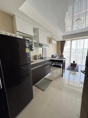 a kitchen with a black refrigerator and a table at Maikhao Beach Condominium in Mai Khao Beach