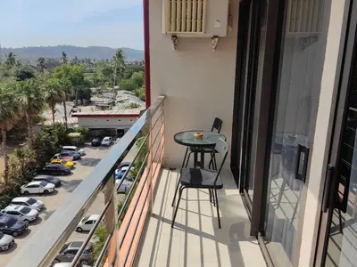 a balcony with a table and a view of a parking lot at Maikhao Beach Condominium in Mai Khao Beach