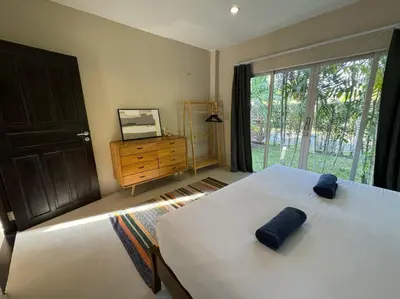 a bedroom with a bed and a window and a dresser at Nai Thon villa with pool, garden, rooftop terrace in Nai Thon Beach
