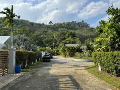 a street with cars parked on the side of a mountain at Nai Thon villa with pool, garden, rooftop terrace in Nai Thon Beach