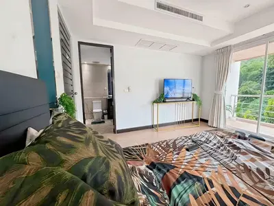 a living room with a bed and a tv at Peaceful Patong Penthouse in Patong Beach