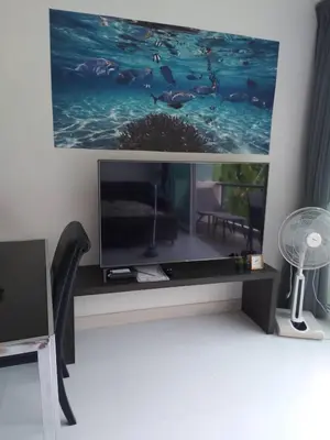 a living room with a flat screen tv on a wall at Karon Butterfly Condominium Brandnew, spacious 65m2 full seaview apartment, large pool, 300m from Karon beach in Karon Beach