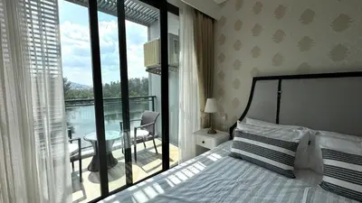 a bedroom with a bed and a view of a balcony at Lake view apartment in Laguna in Bang Tao Beach