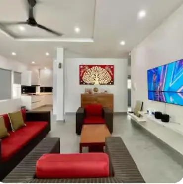 a living room with a red couch and red chairs at Pool Villa in Thalang in Ban Na Nai