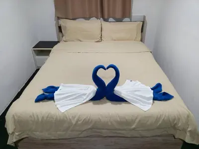 a bed with a blue ribbon in the shape of a heart at Patong Beach Dream House in Patong Beach