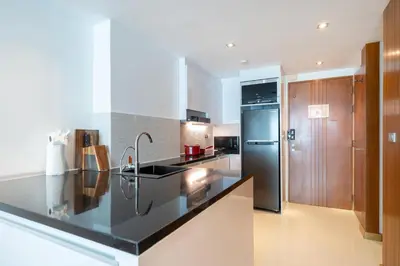 a kitchen with a black counter top and a refrigerator at Spacious apartment with ocean view & jacuzzi in Patong Beach