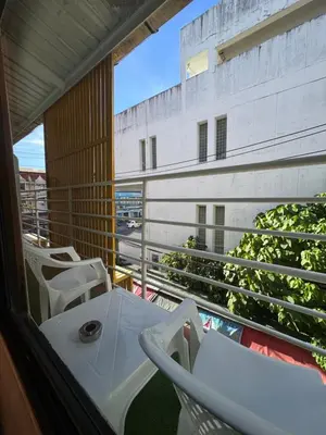 a balcony with tables and chairs on a building at Pupa Women Hostel in Patong Beach