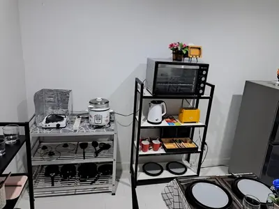 a room with a kitchen with a stove and a tv at 2 bedroom house in Thalang in Ban Pak Lak