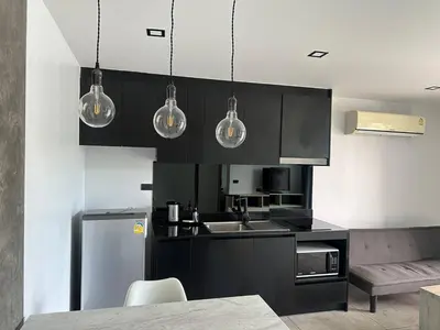 a kitchen with black cabinets and stainless steel appliances at 1-bedroom apartment Naiharn Beach B403 in Rawai Beach