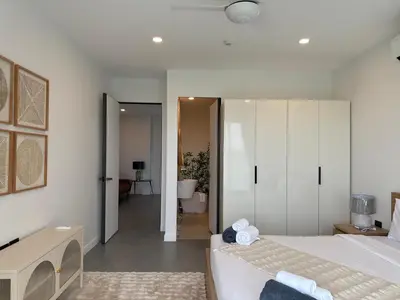 a white bedroom with a bed and a bathroom at Luxury 3BR Triplex Jacuzzi & Sea View PANDORA RESIDENCES in Nai Harn Beach