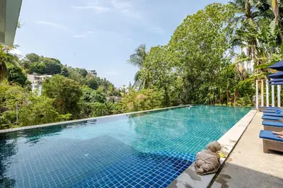 a teddy bear sitting next to a swimming pool at Exquisite Sea View Luxury Apartment Veloche group in Karon Beach