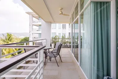 a balcony with a table and chairs on it at Exquisite Sea View Luxury Apartment Veloche group in Karon Beach